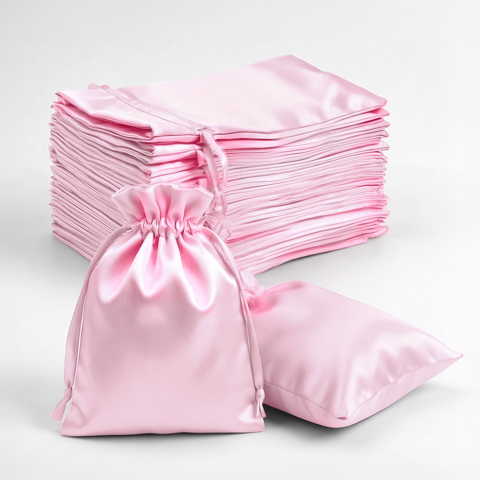 Pink satin drawstring favor gift bags, perfect for weddings and parties.