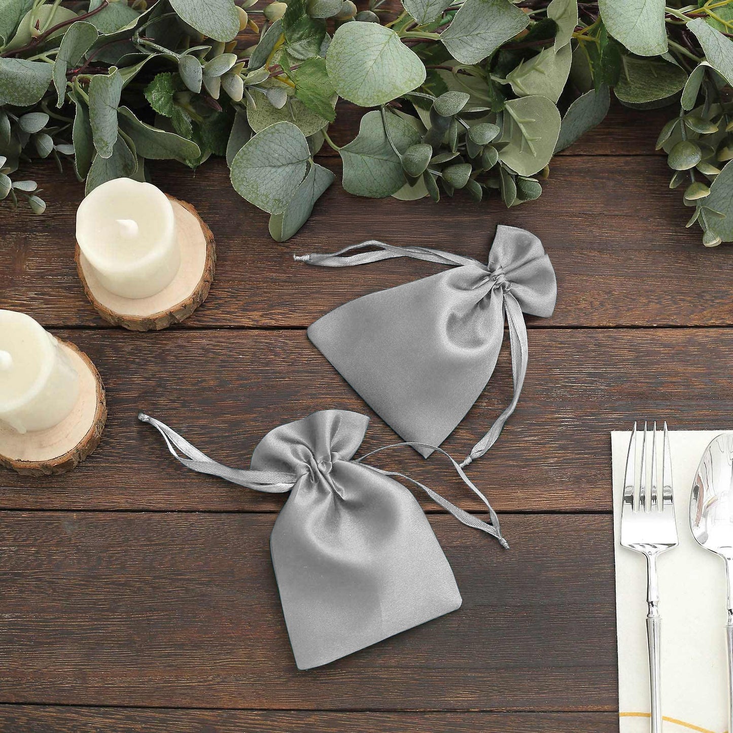 Silver satin drawstring favor bags for weddings and parties.
