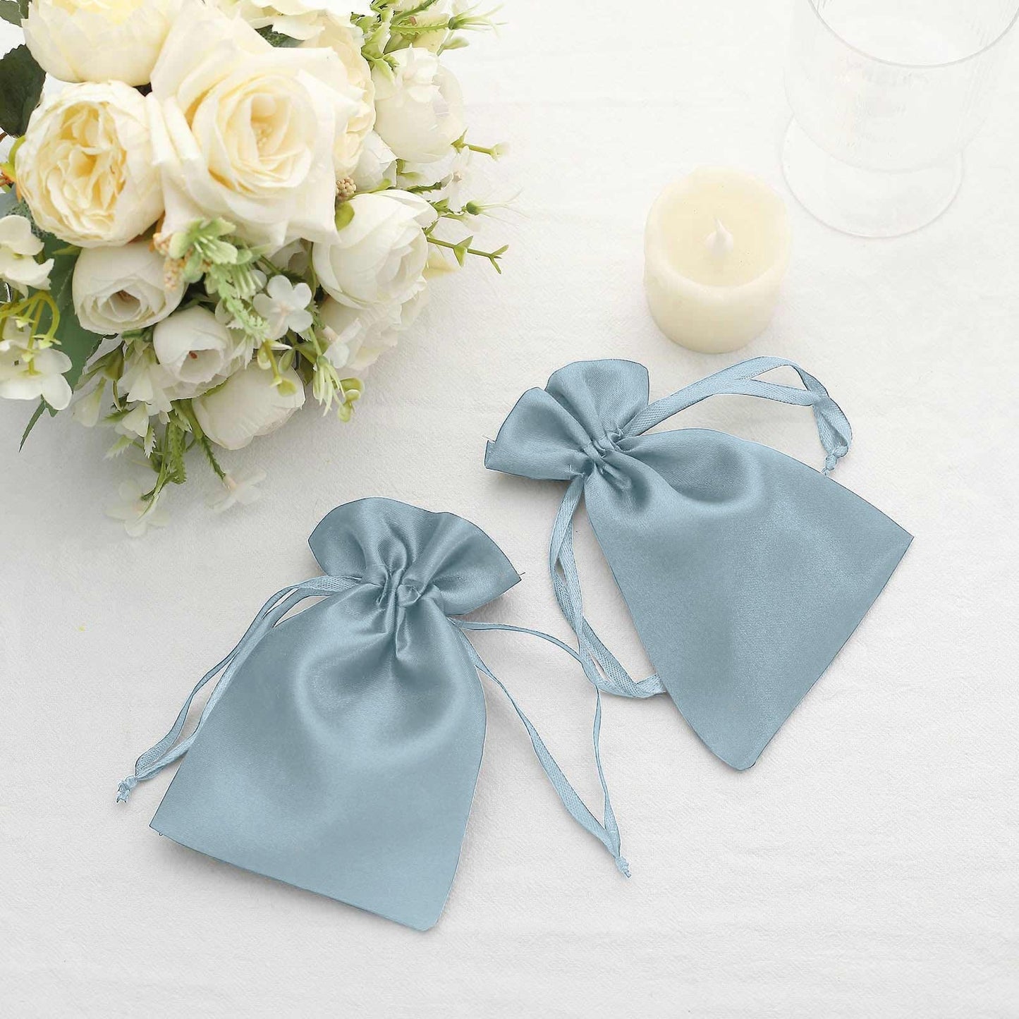 Dusty blue satin drawstring pouches for wedding party favors.