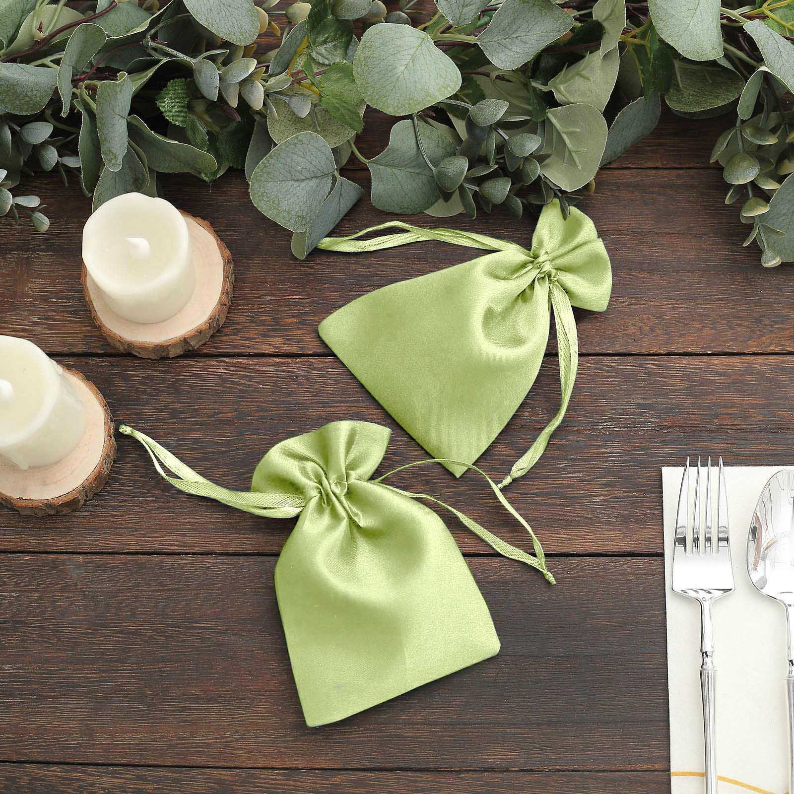 Apple green satin drawstring pouch gift bags on a rustic table setting.
