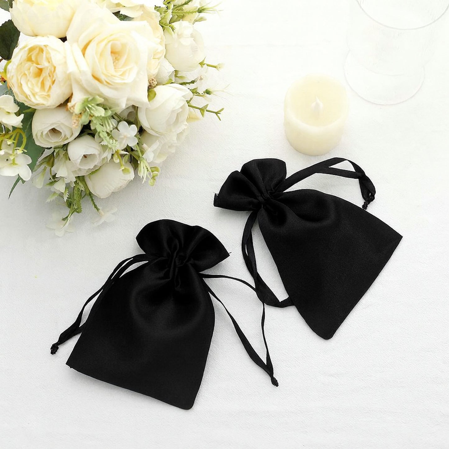 Black satin drawstring pouch gift bags for wedding party favors.