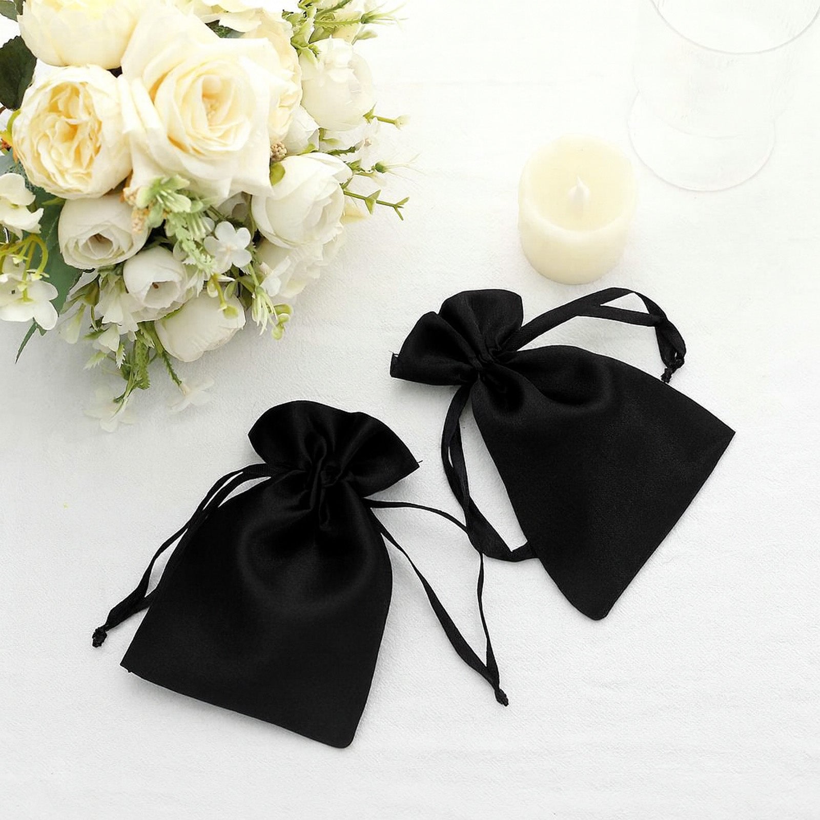 Black satin drawstring pouch gift bags for wedding party favors.