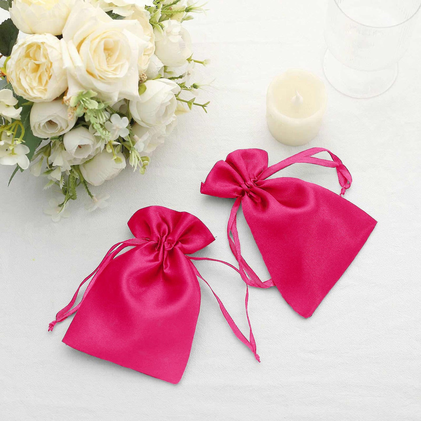 Fuchsia satin drawstring favor bags for weddings and parties.