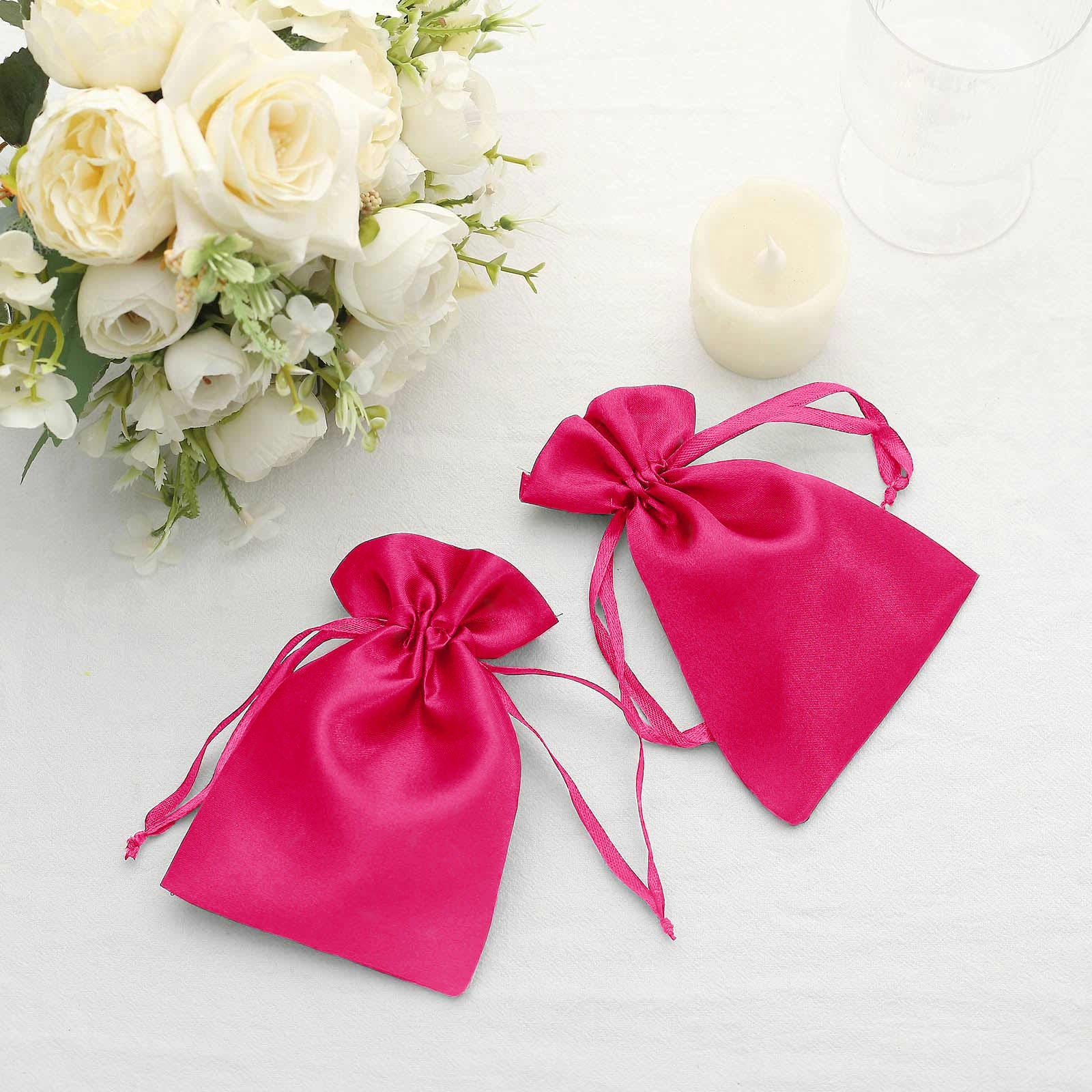 Fuchsia satin drawstring favor bags for weddings and parties.