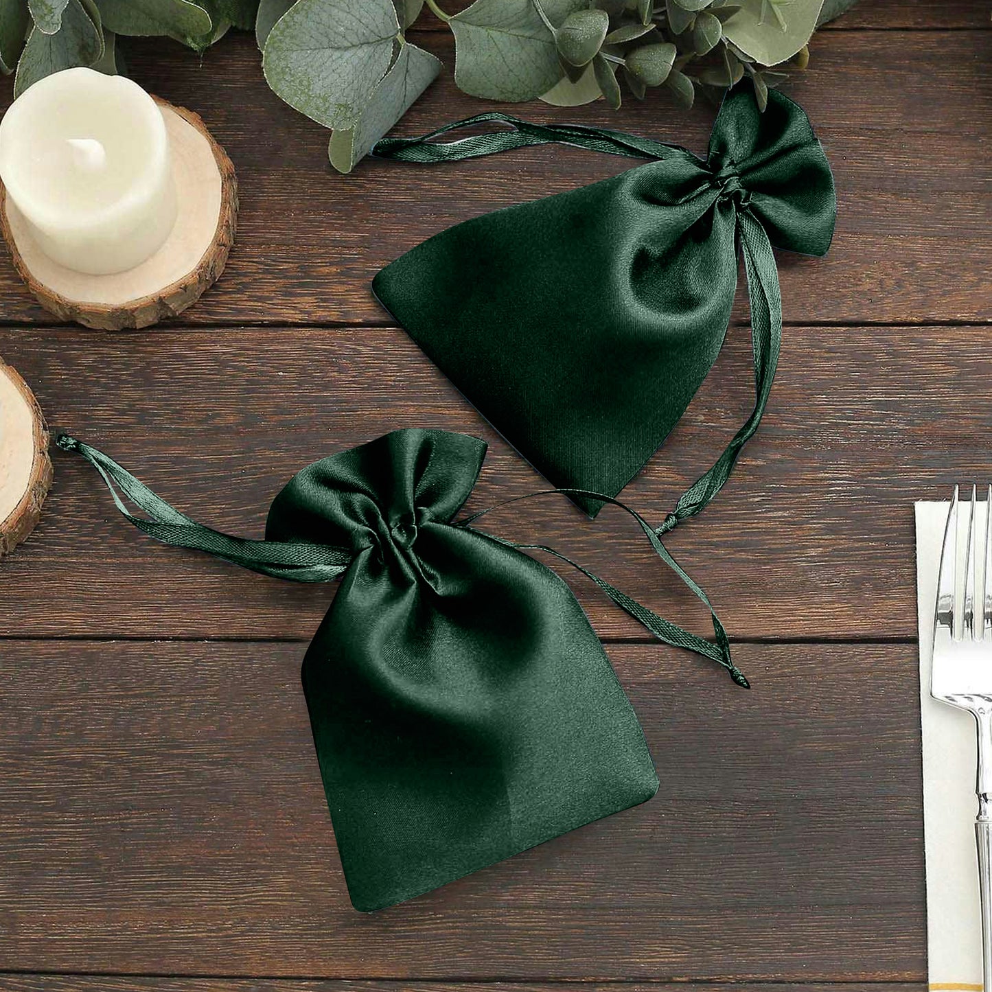 Emerald green satin drawstring pouches for wedding party favors.