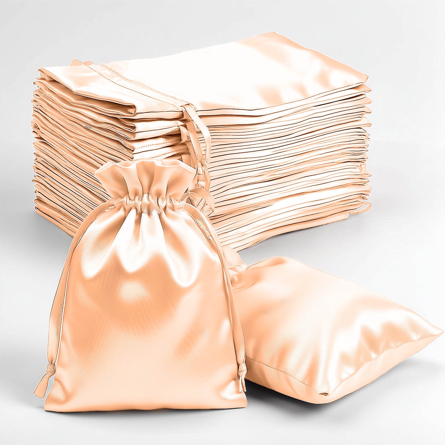 Peach satin drawstring gift bags for weddings, party favors, and gifts.
