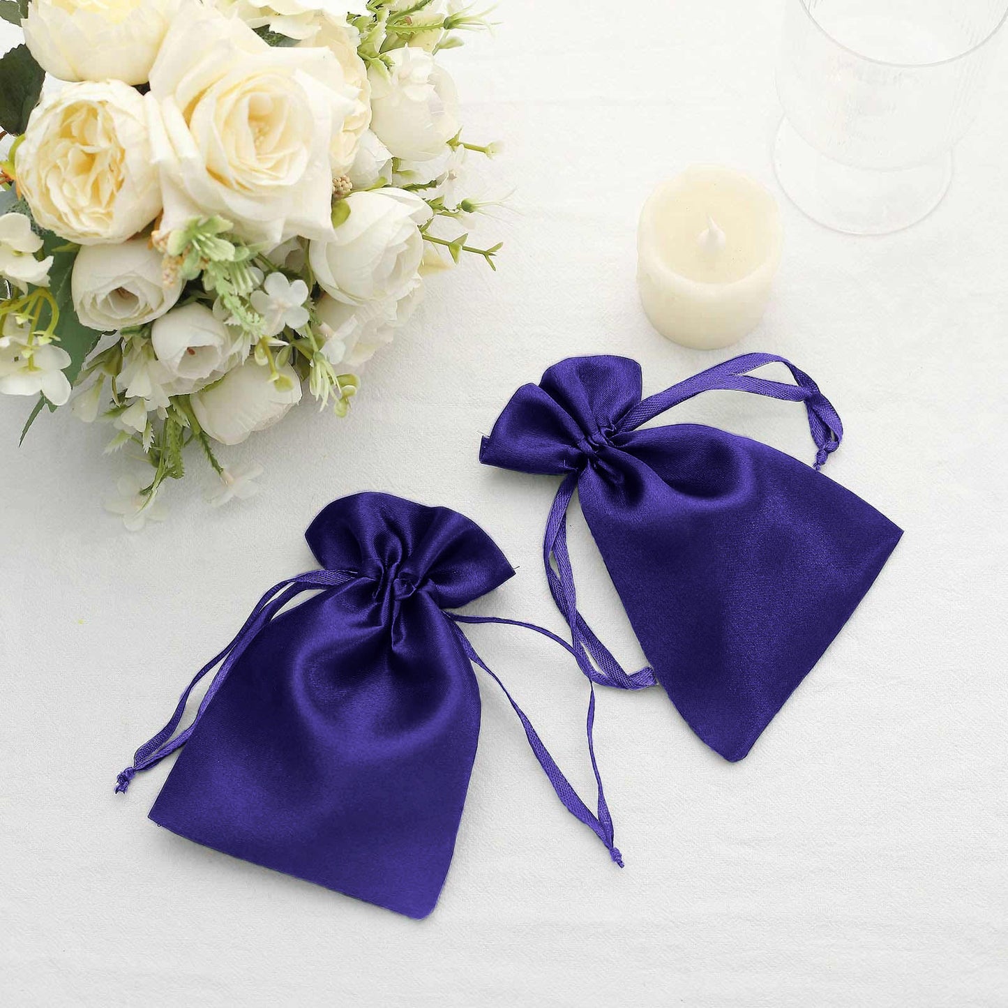 Purple satin drawstring gift bags for wedding favors.