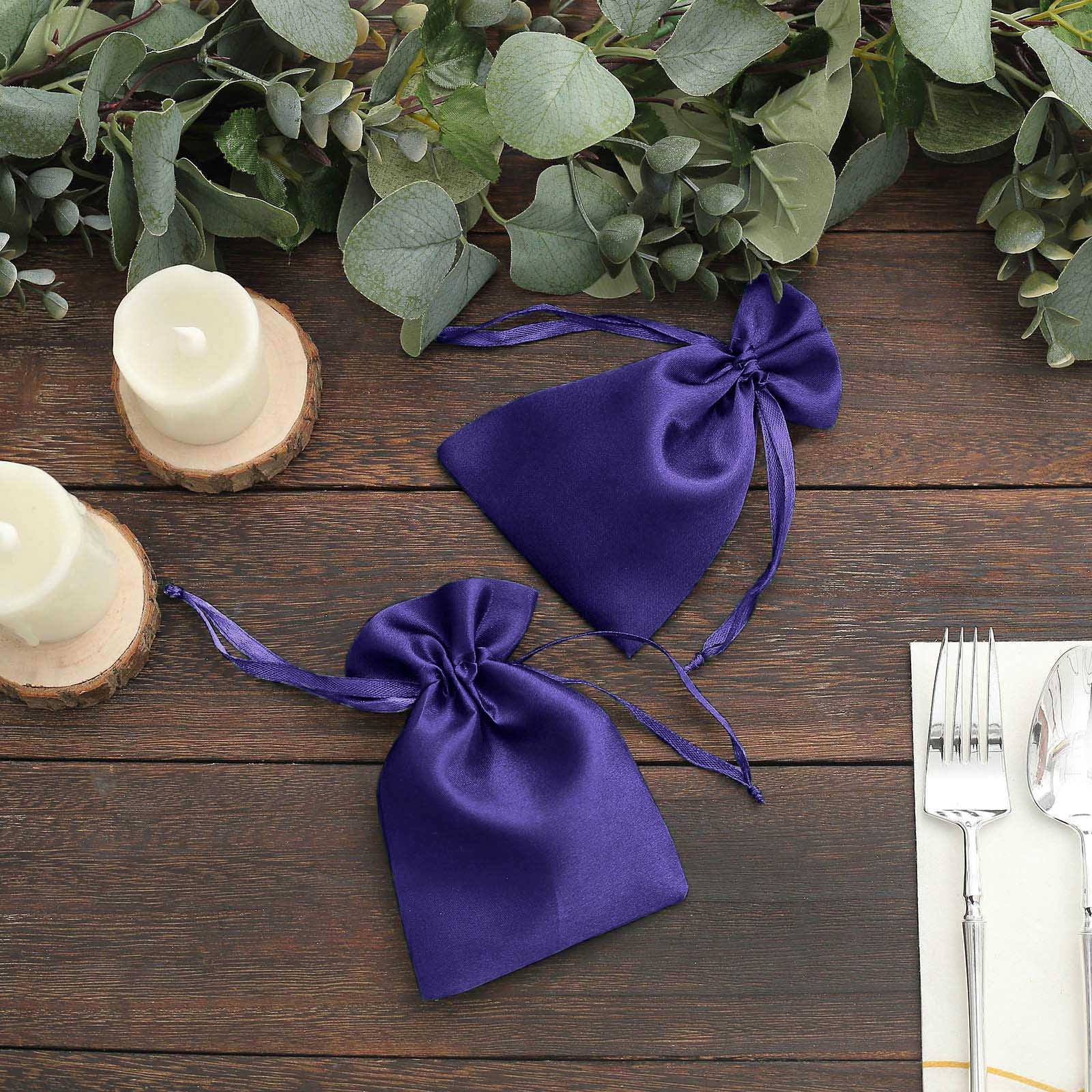 Purple satin drawstring pouch gift bags on a rustic table setting.