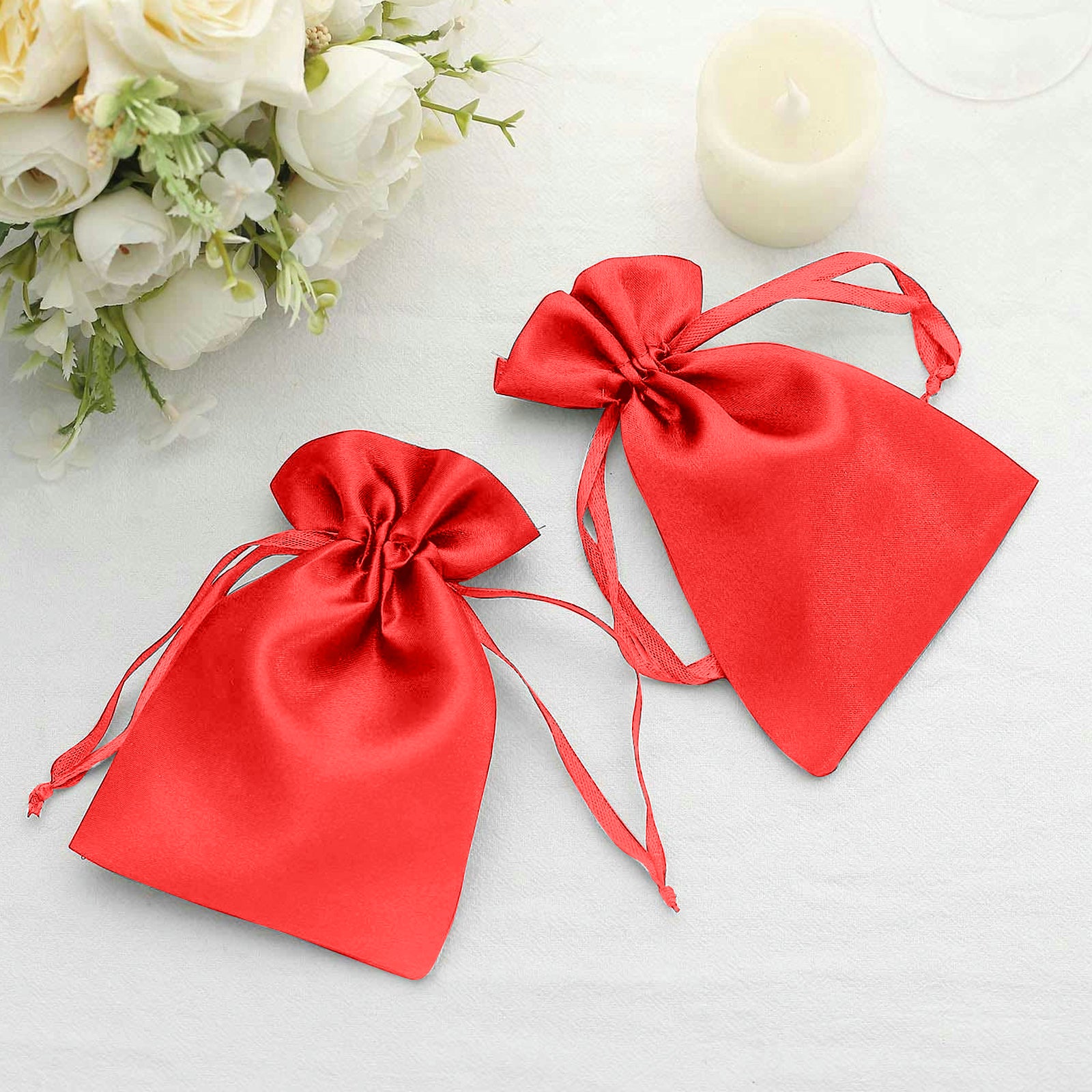 Red satin drawstring pouch gift bags for wedding favors.