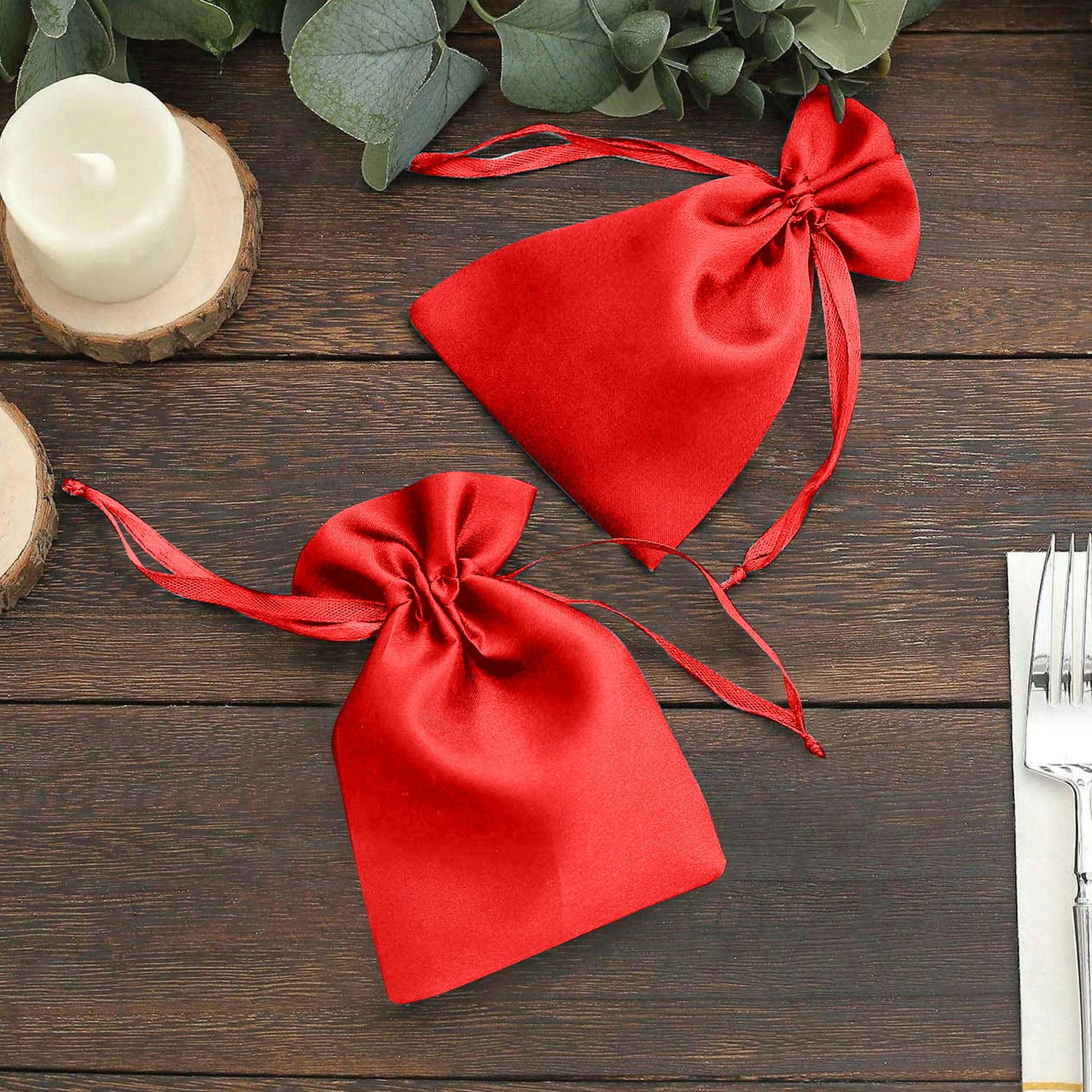 Red satin drawstring gift bags for wedding party favors.