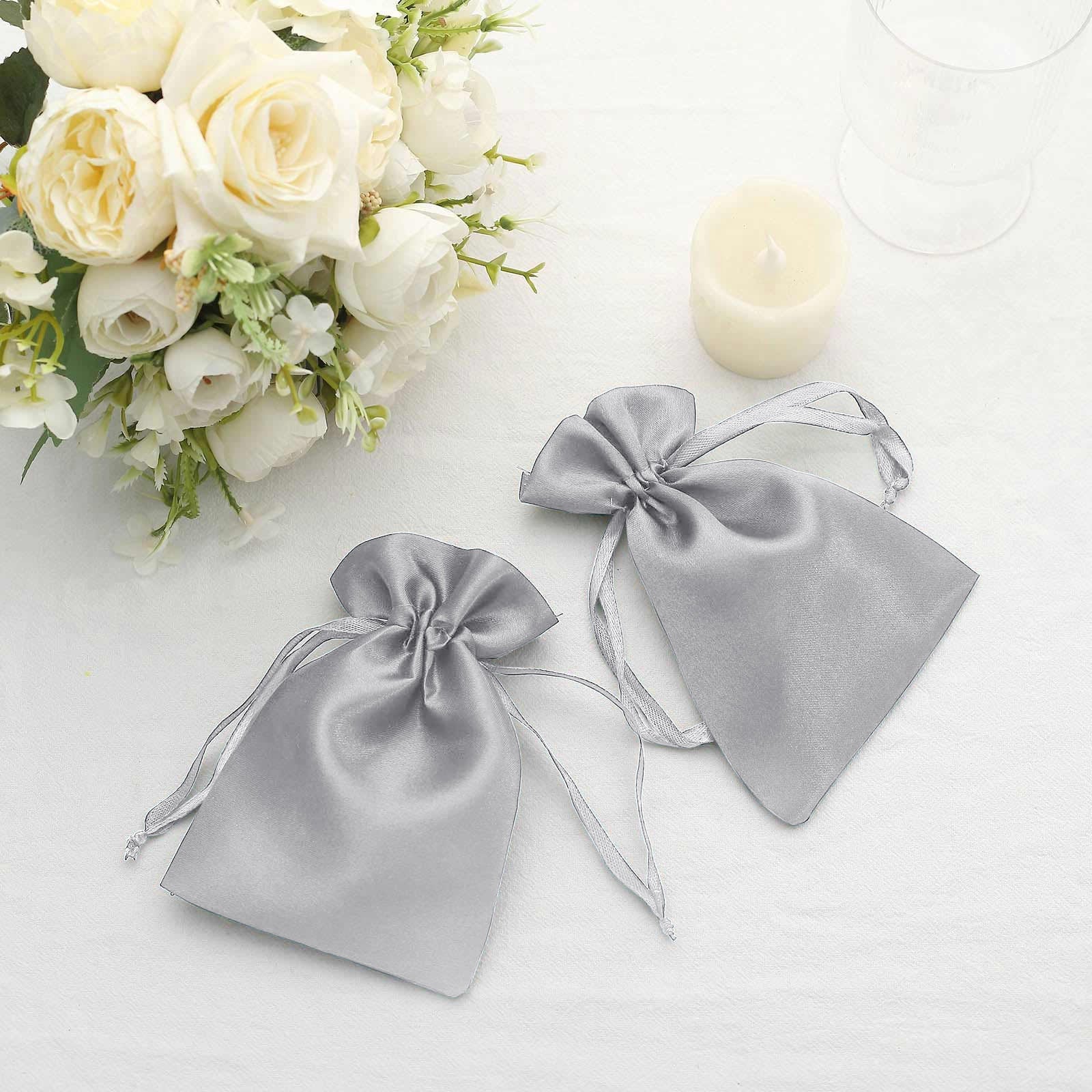 Silver satin drawstring pouches for wedding party favors.