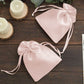 Blush satin drawstring gift bags for wedding party favors.
