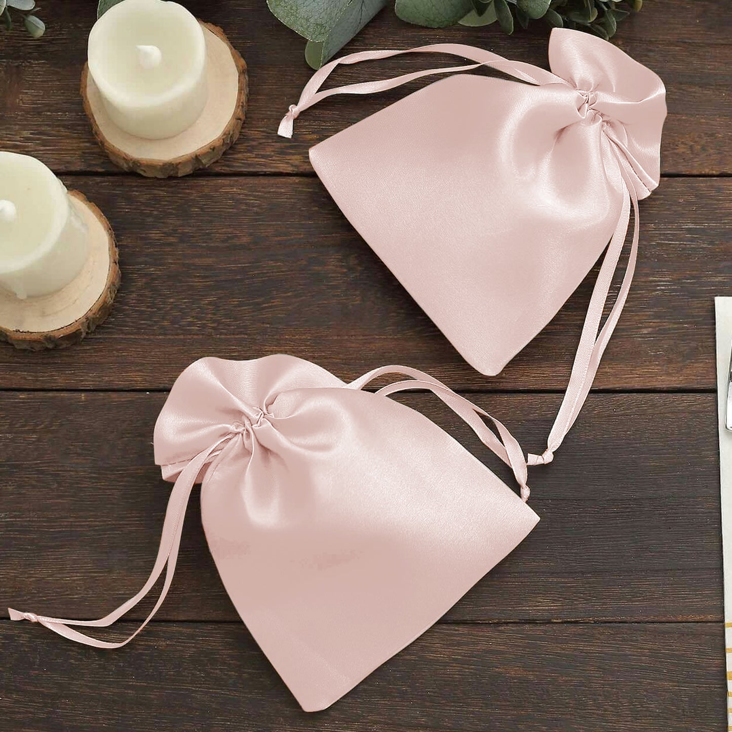 Blush satin drawstring gift bags for wedding party favors.