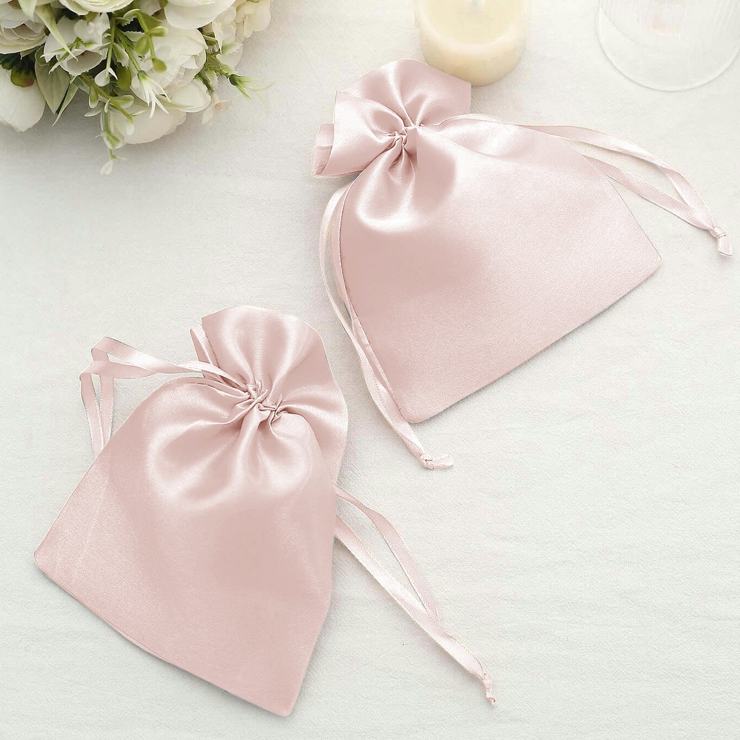 Blush satin drawstring bags for wedding party favors.