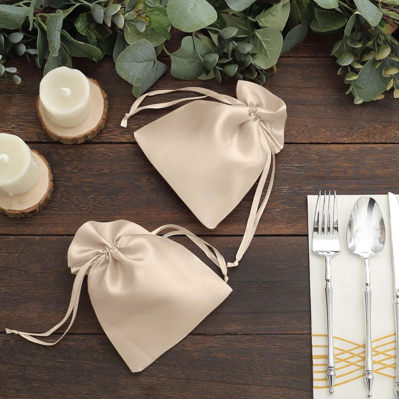 Beige satin drawstring gift bags for wedding favors.