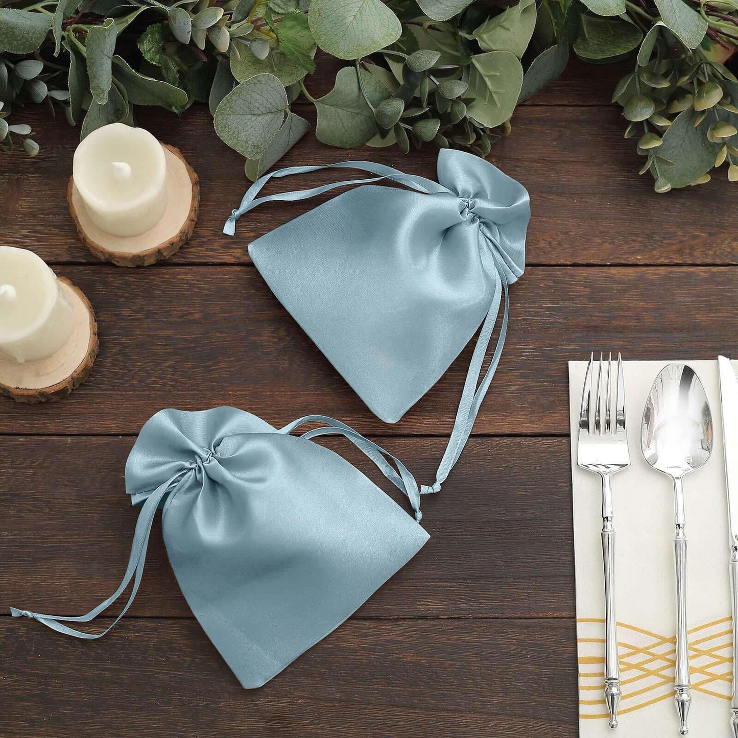 Dusty blue satin drawstring gift bags for wedding party favors.
