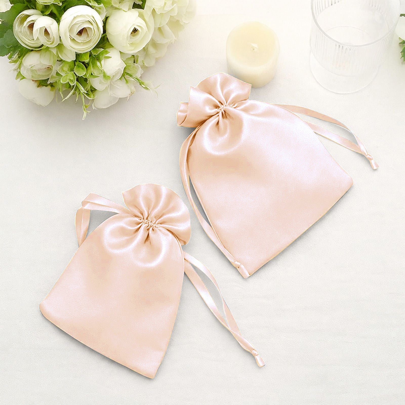 Peach satin drawstring gift bags for wedding party favors.