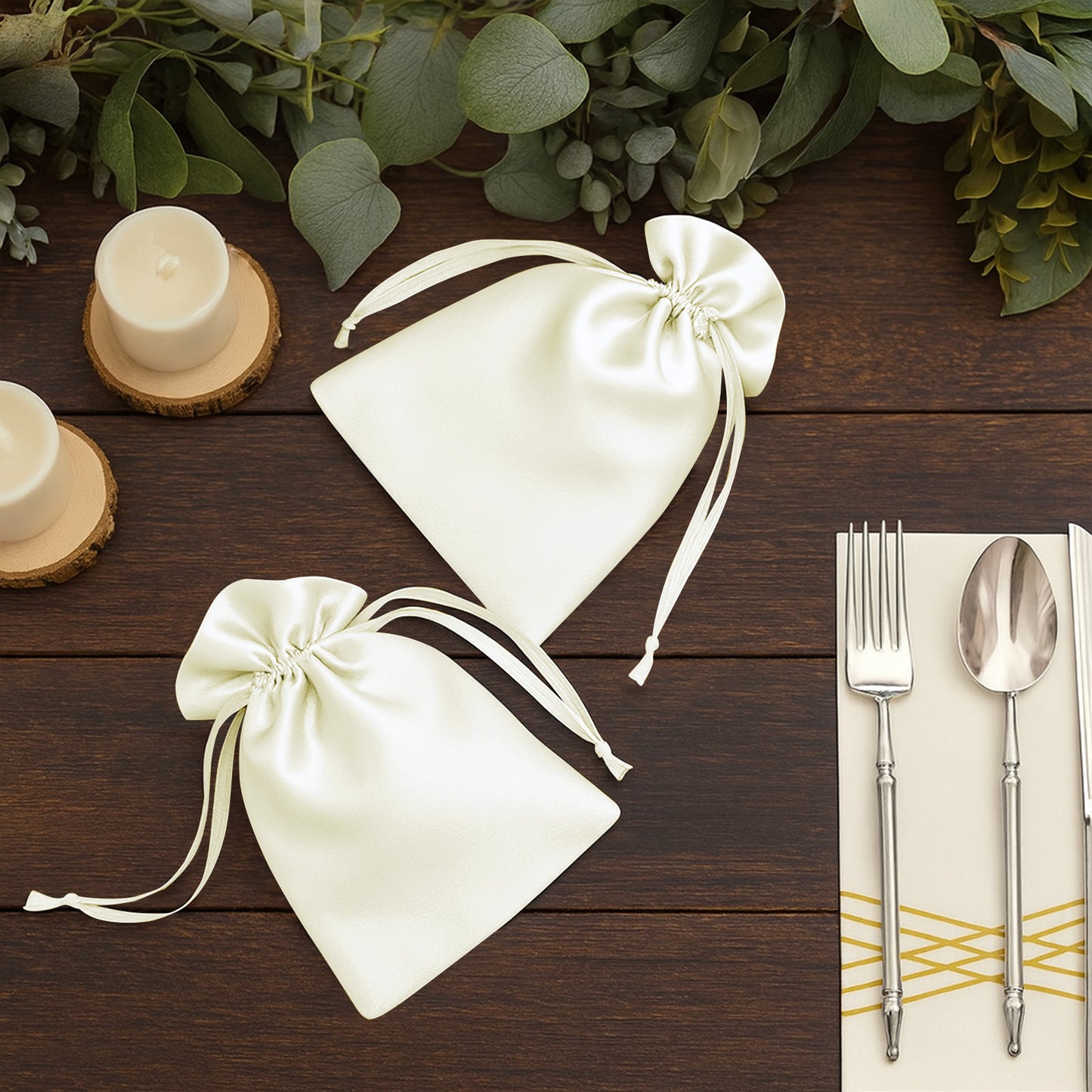 White satin drawstring wedding favor gift bags on wooden table