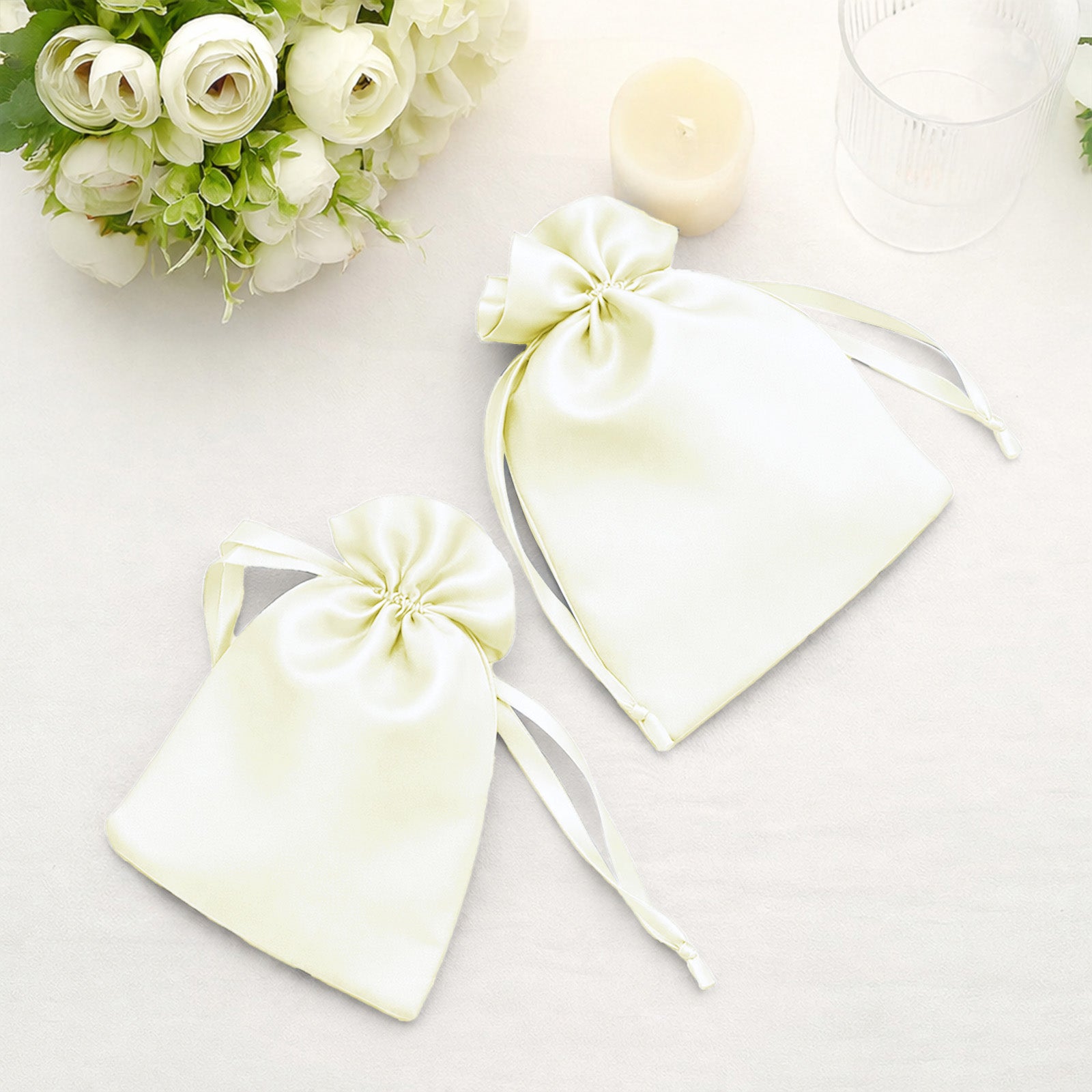 Yellow satin drawstring wedding favor bags on a table.