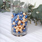 Navy blue and gold faux pearl beads in a glass vase.