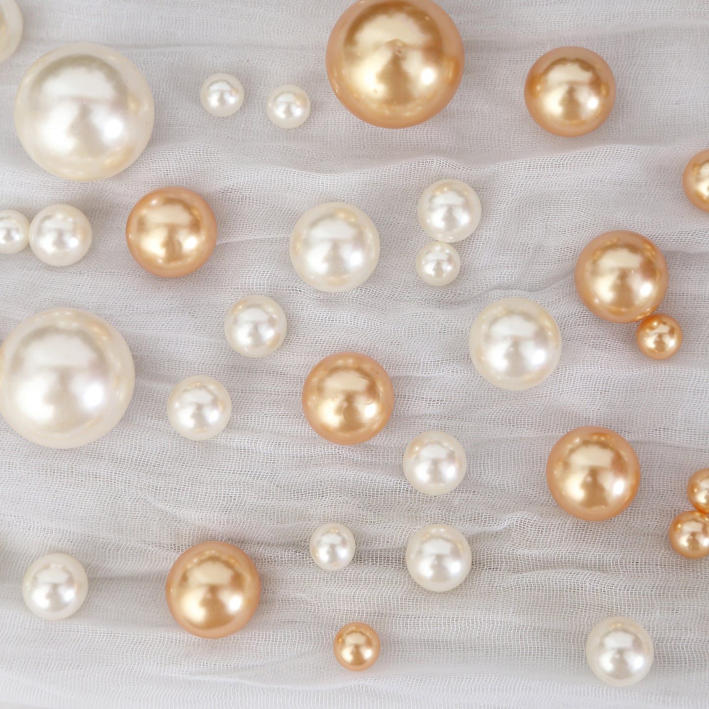 Assorted off white and gold faux pearl beads for DIY crafts.