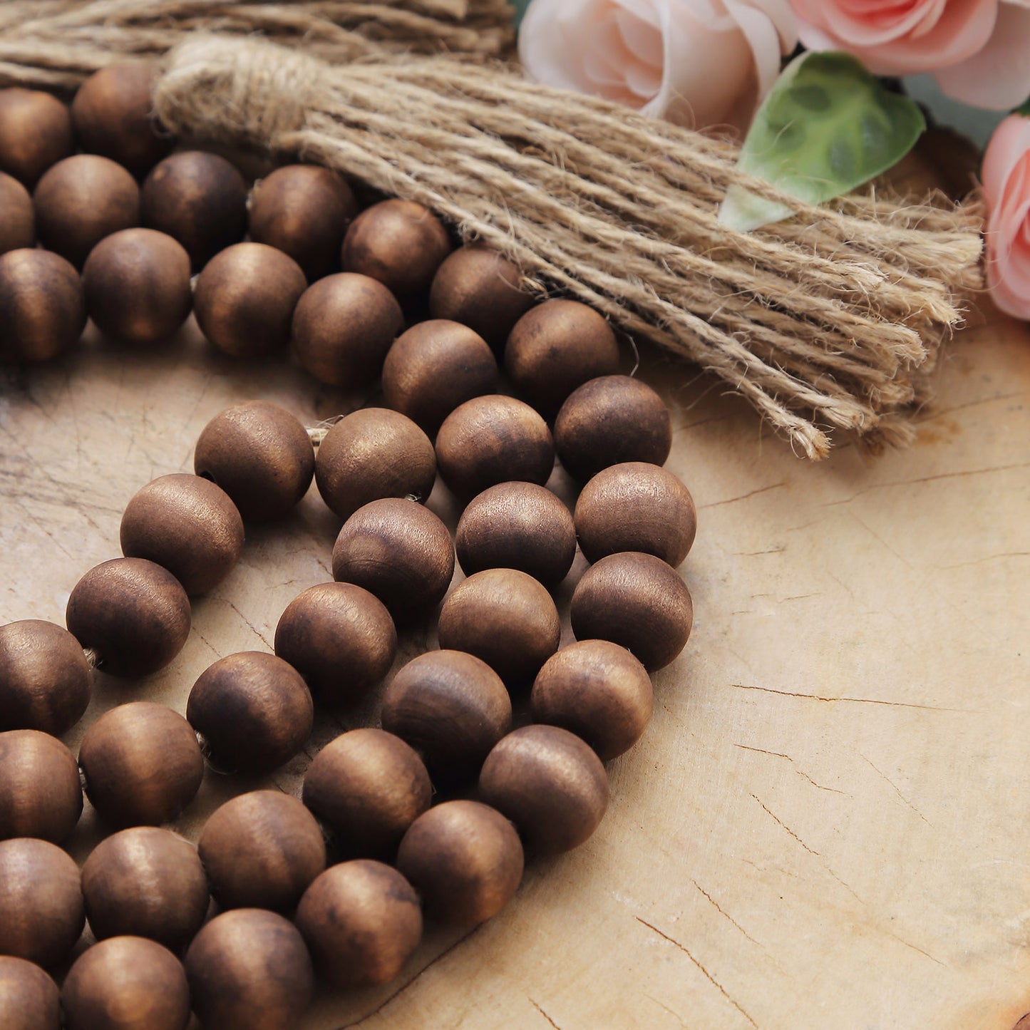Brown rustic wood bead garland with tassels for farmhouse decor.