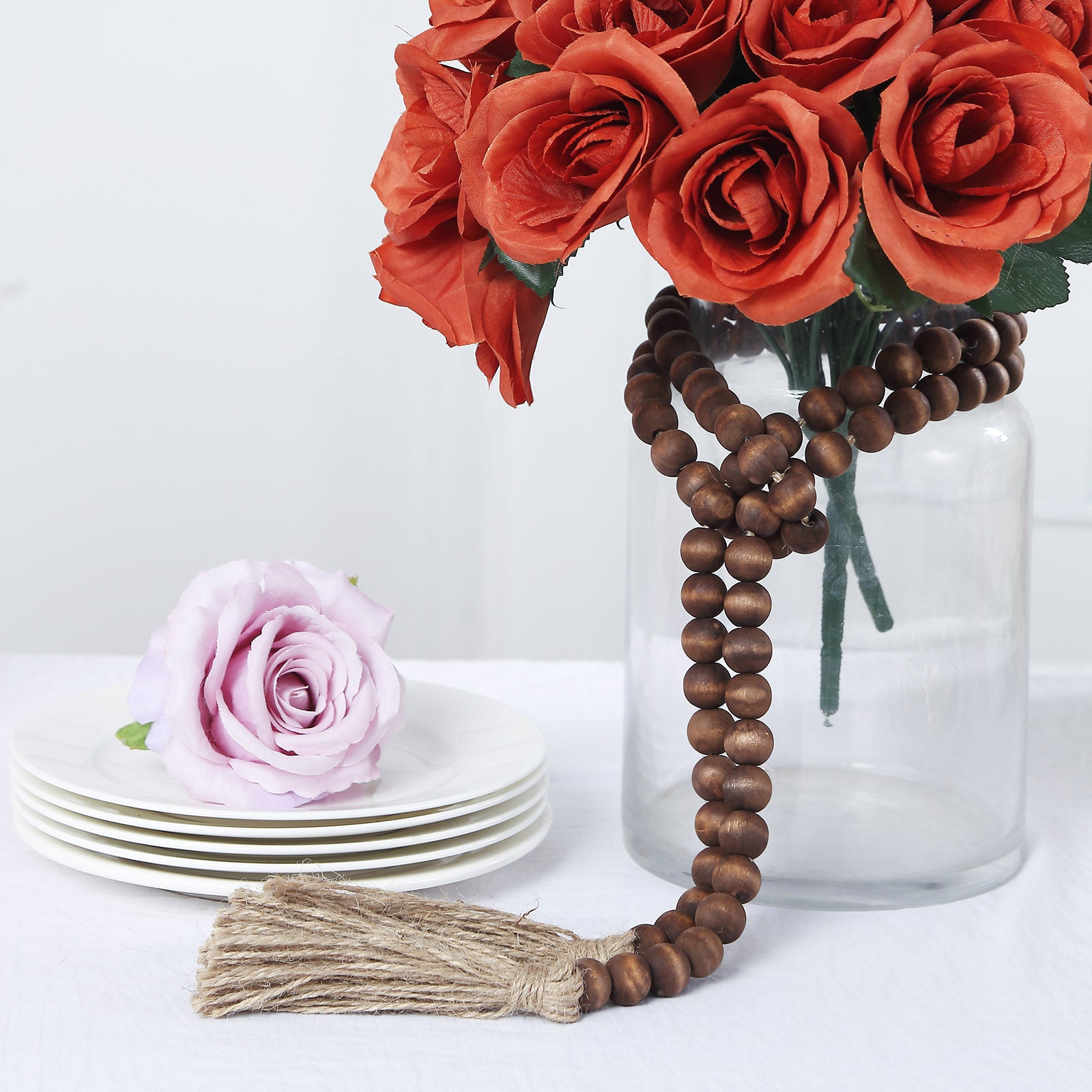 Brown rustic wood bead garland with tassels, perfect for farmhouse decor.