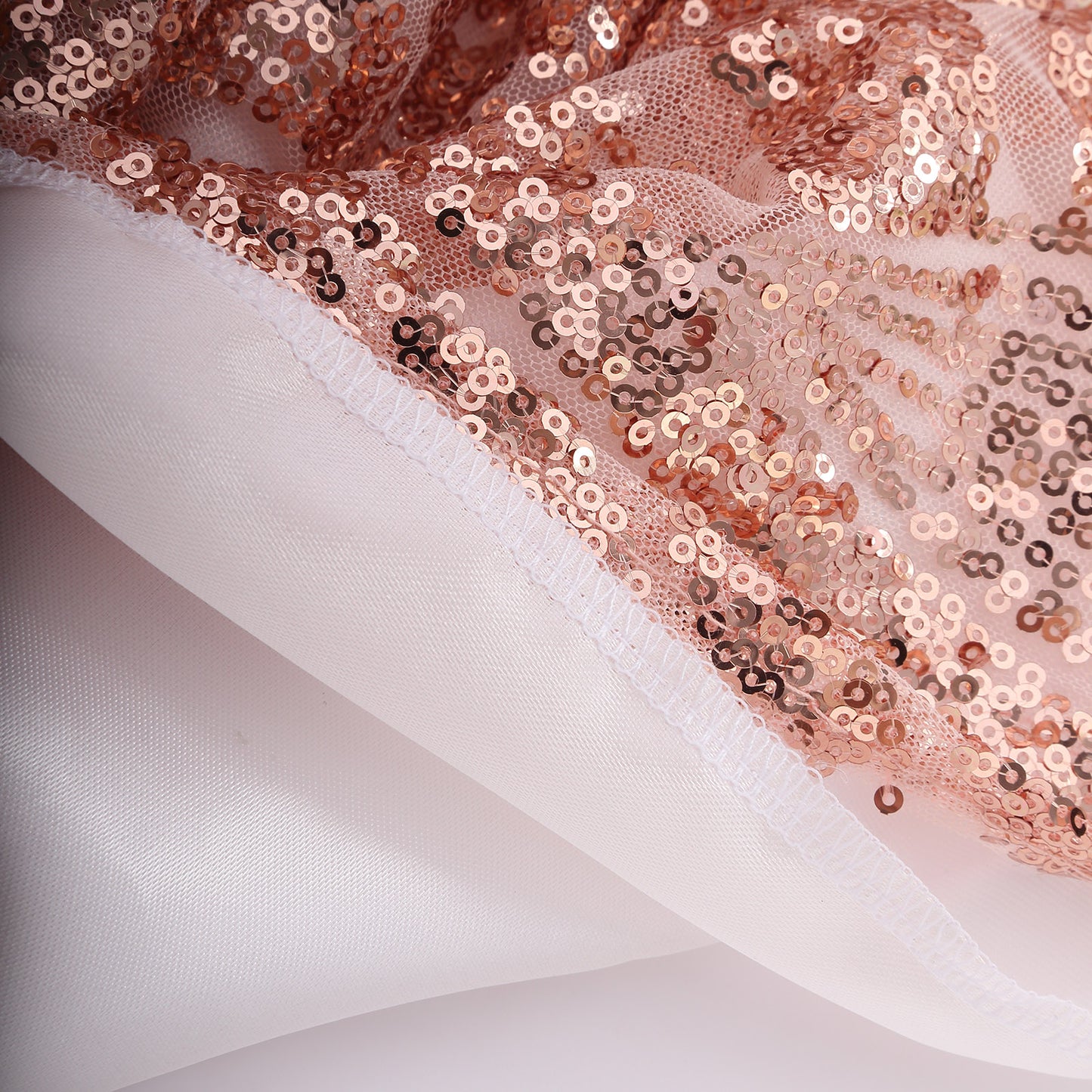 Rose gold sequin backdrop with satin backing and diamond glitz pattern.
