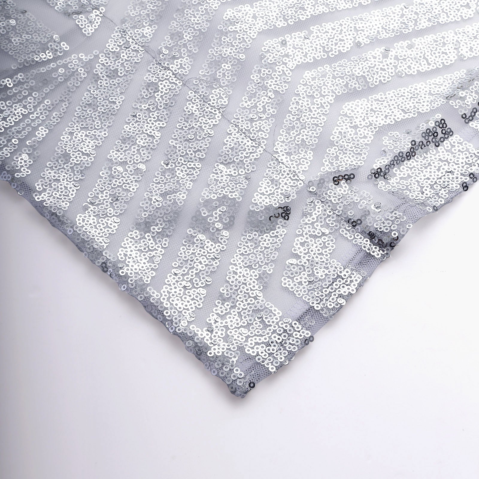 Silver geometric sequin backdrop with satin backing in diamond glitz pattern.