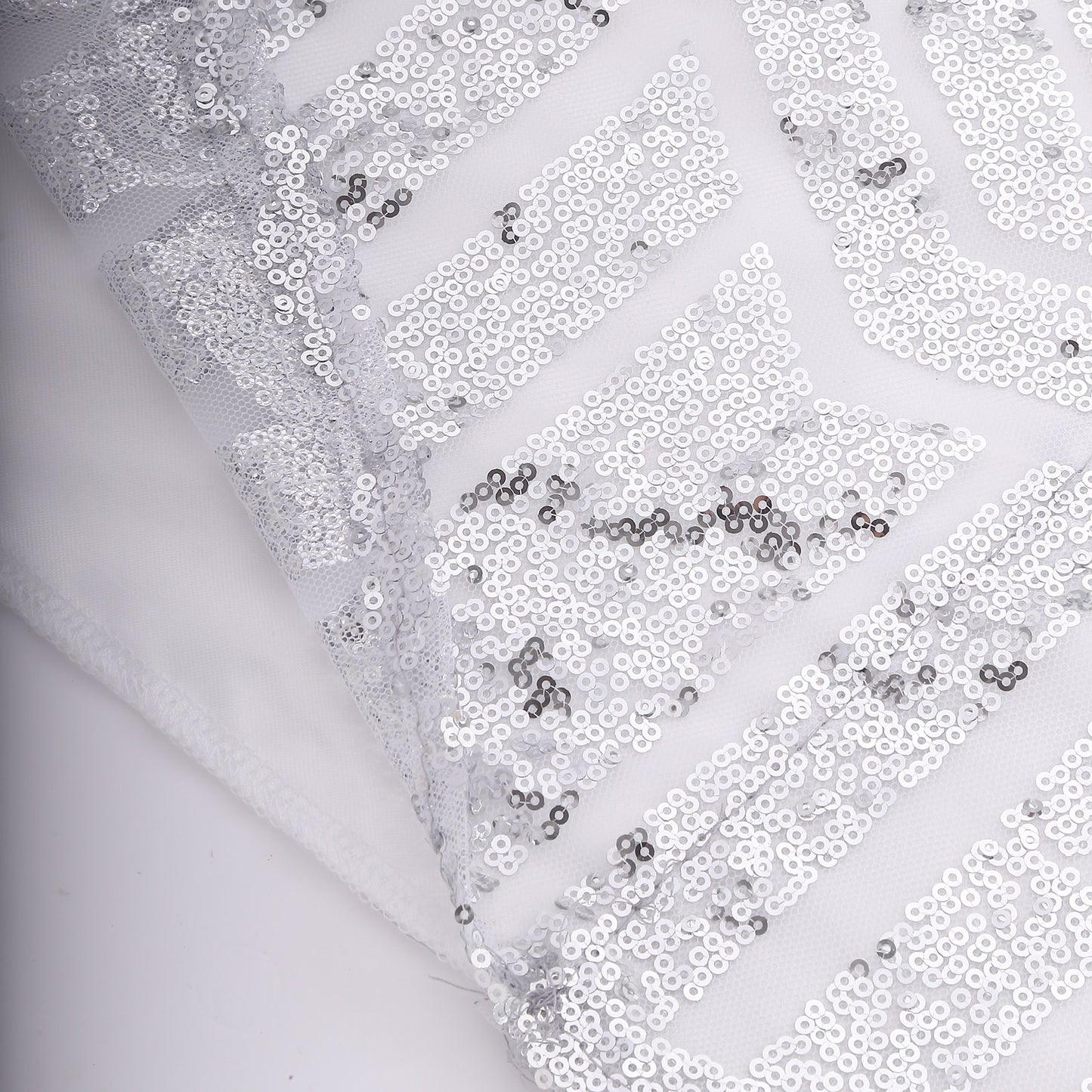 Silver geometric sequin event curtain drapes with satin backing.