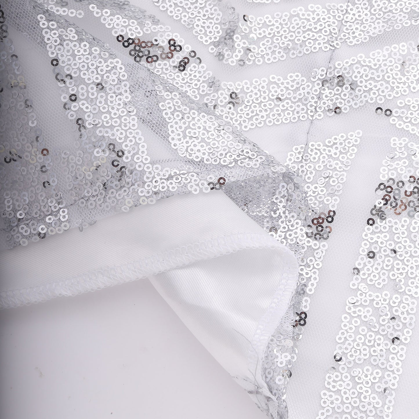 Silver geometric sequin event curtain drapes with satin backing.