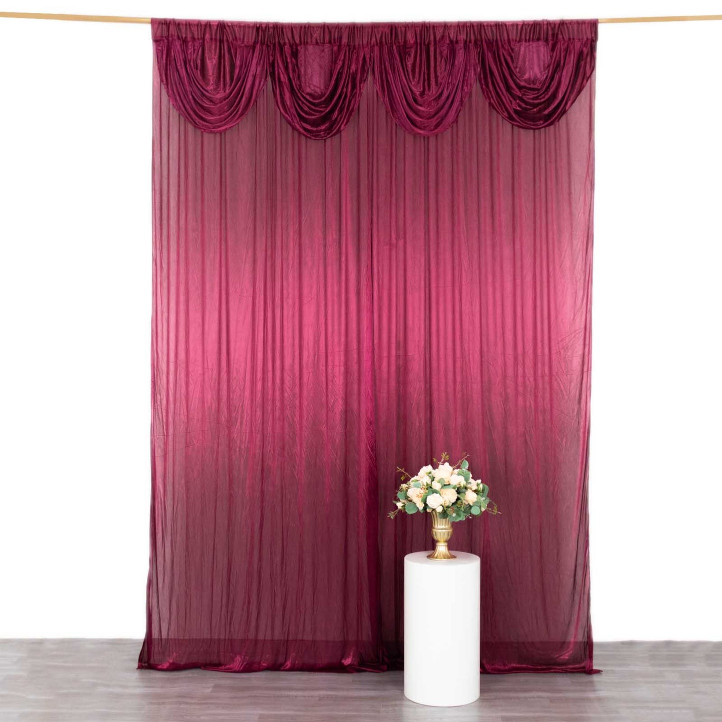 Burgundy pleated satin event curtain drape backdrop with glossy finish.