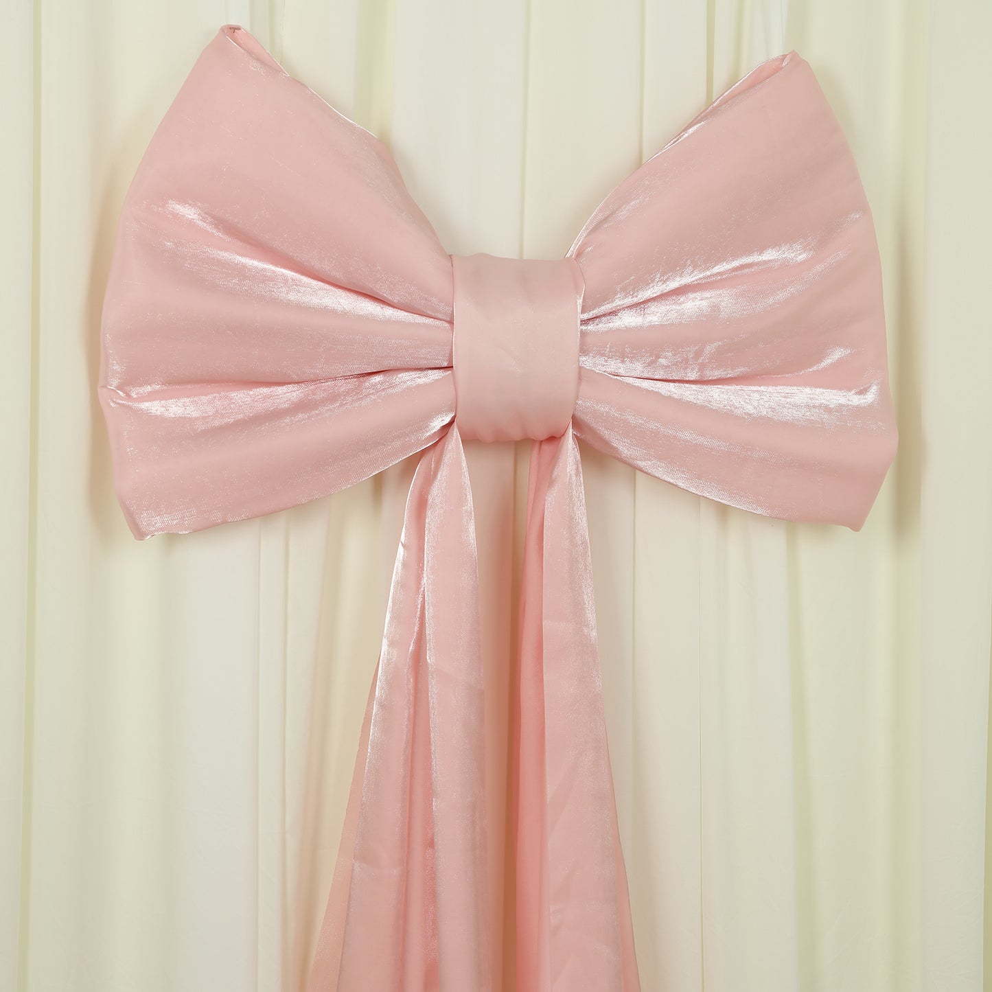 Blush pink giant bow tie décor for wedding and event backdrops.