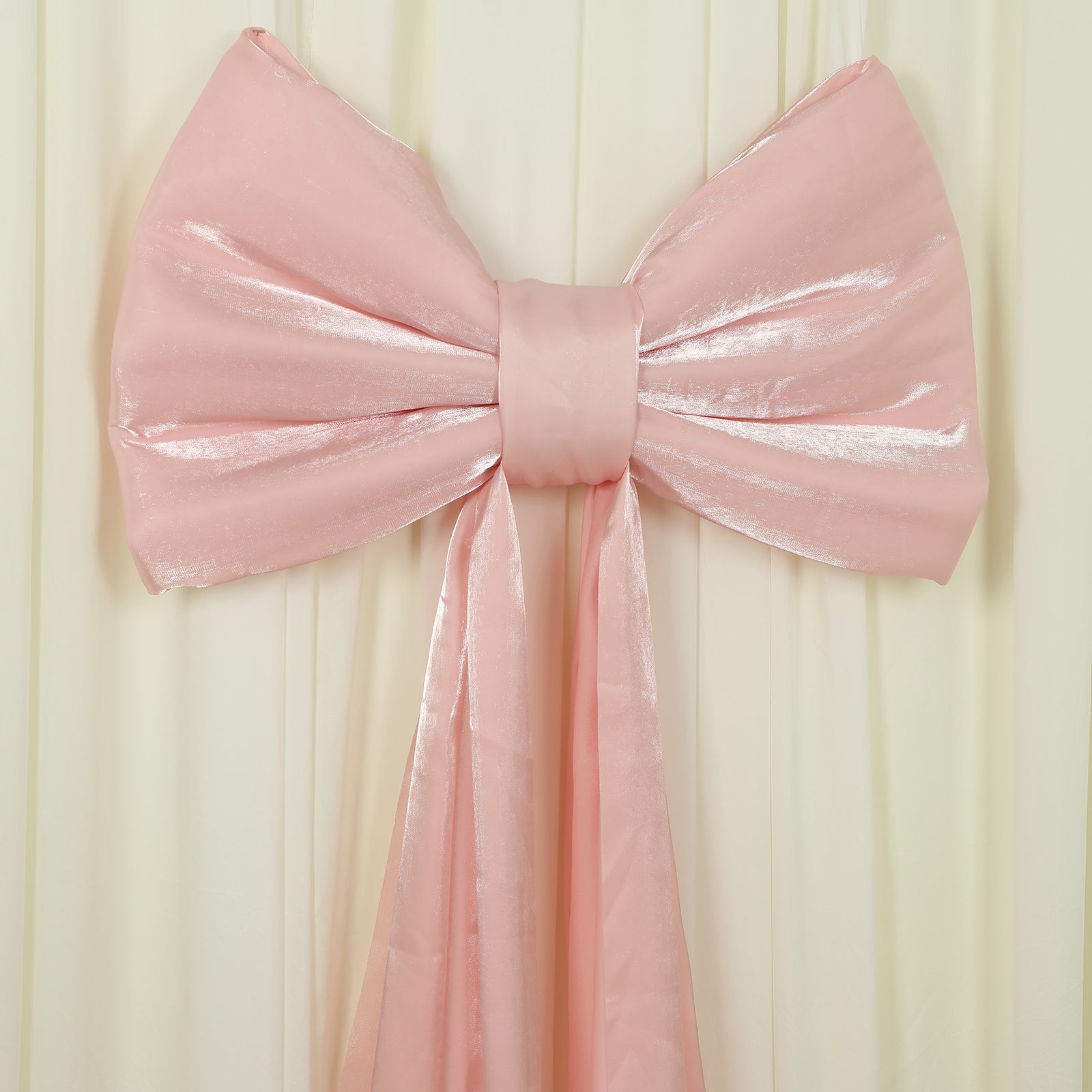 Blush pink giant bow tie décor for wedding and event backdrops.