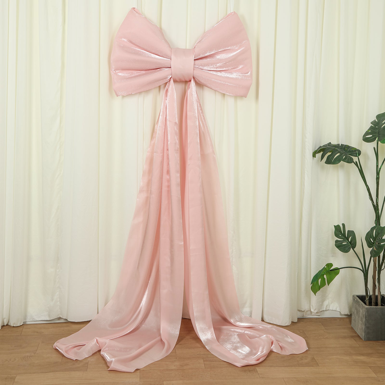 Blush pink giant bow tie décor for wedding and event backdrops.