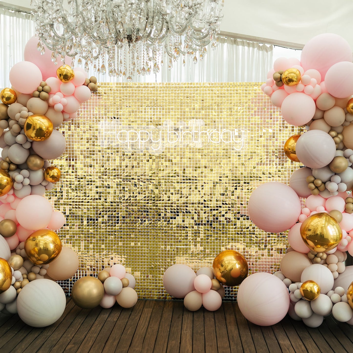 Shiny gold sequin backdrop with balloon decor for party celebration.