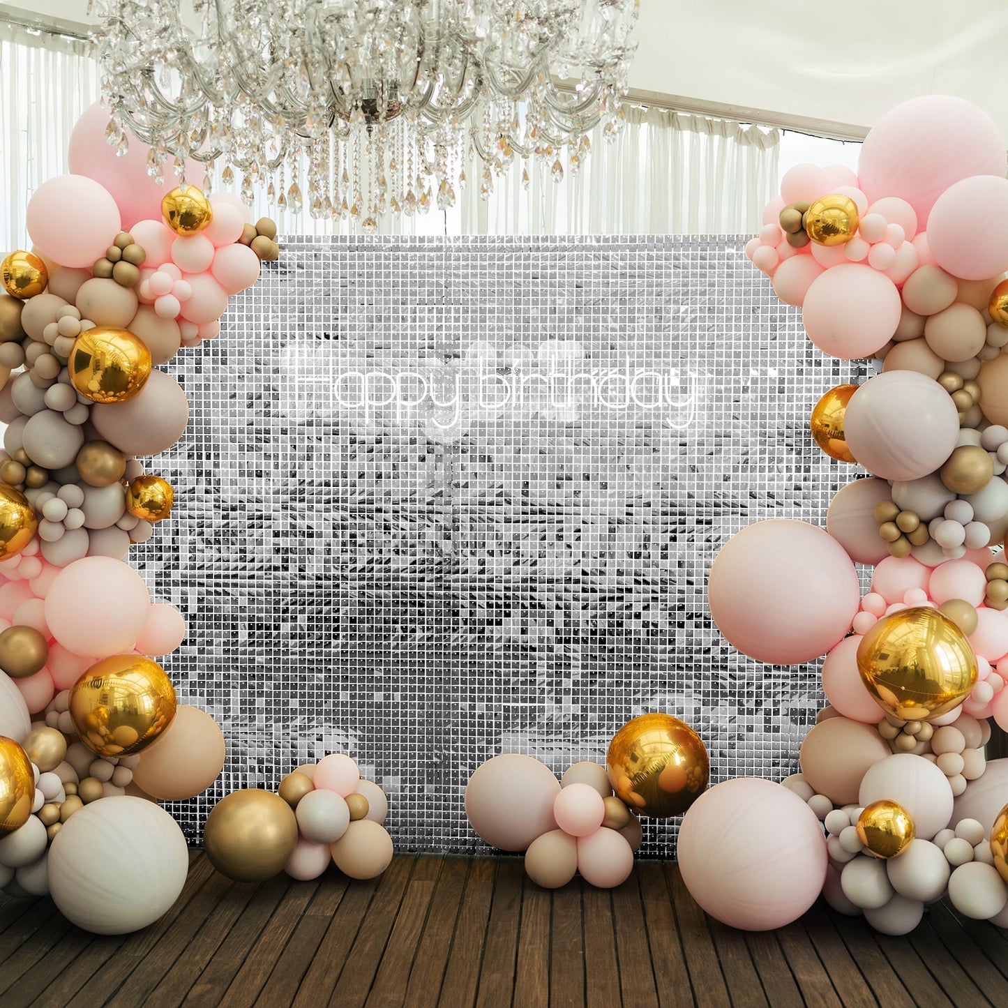 Shiny silver sequin backdrop with pink and gold balloon decorations.