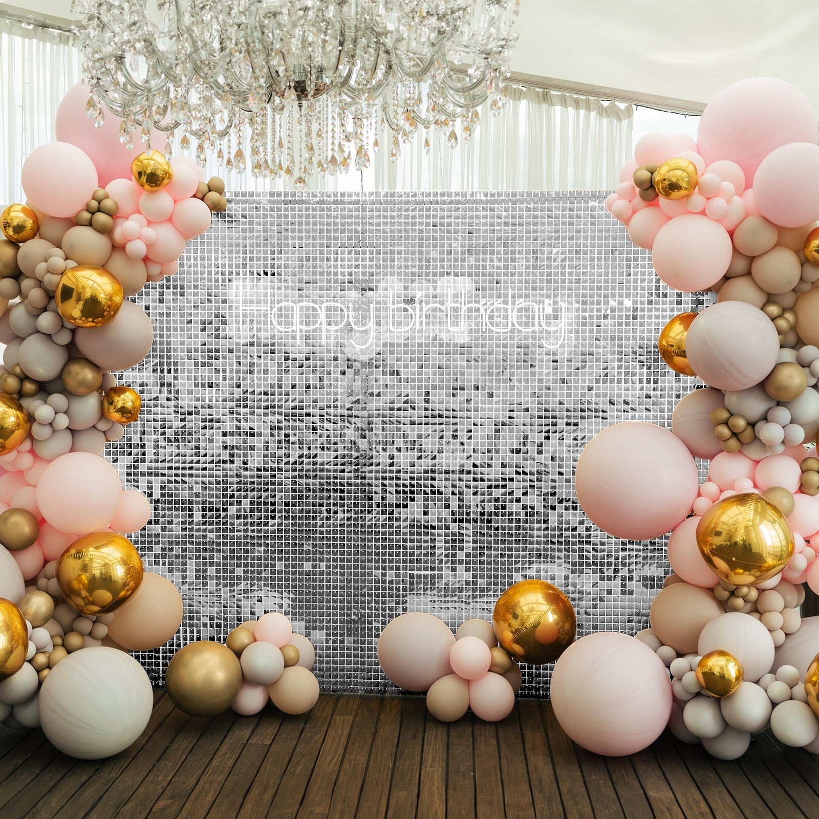 Shiny silver sequin backdrop with pink and gold balloon decorations.