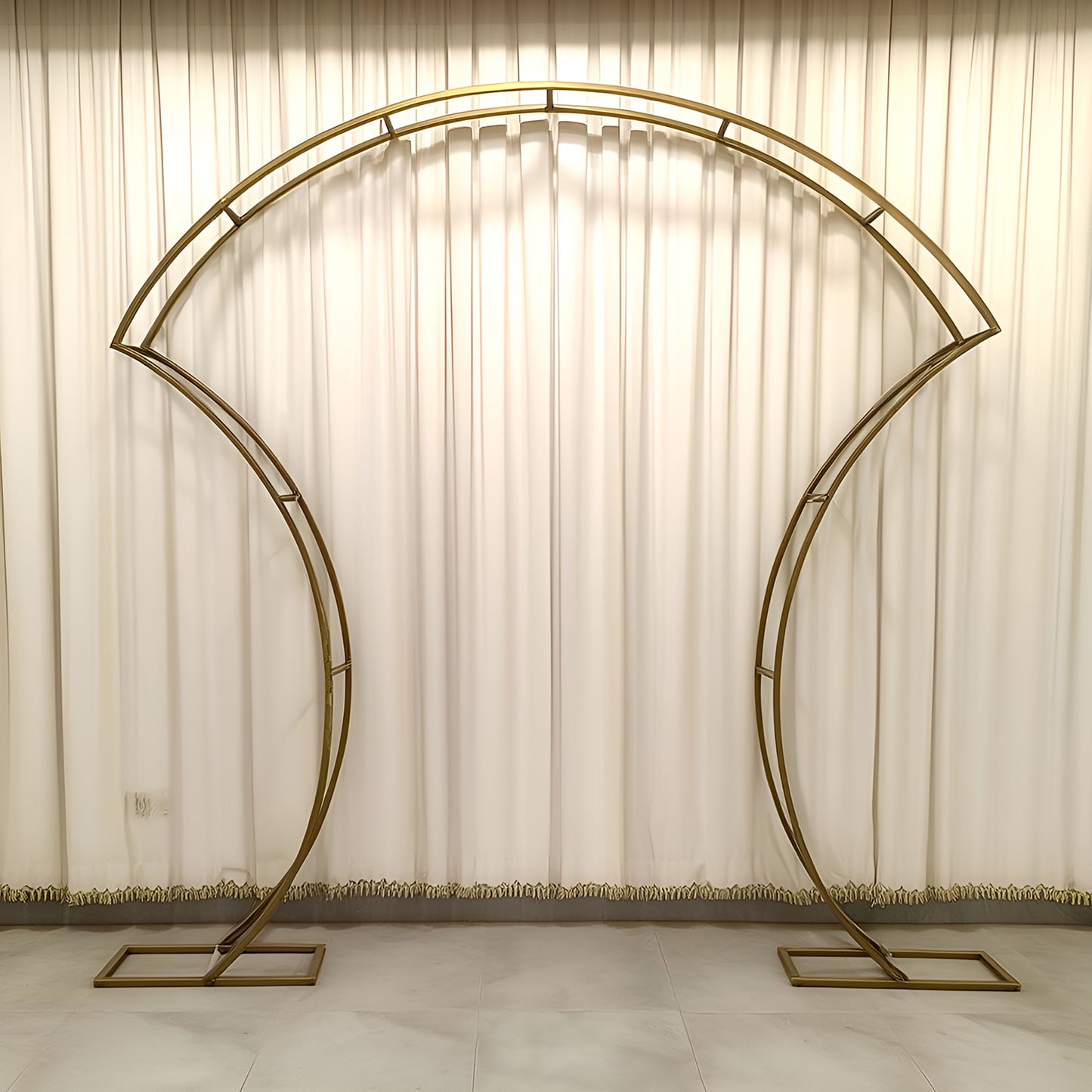 Gold double-curved metal arch frame for backdrops and displays.