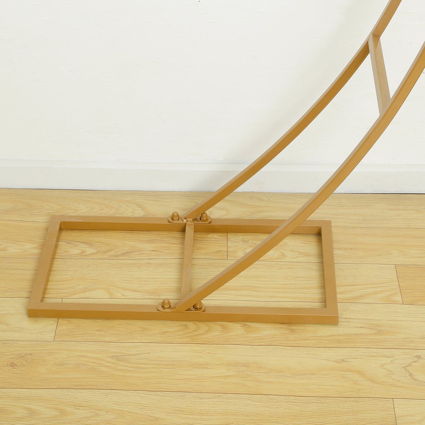 Gold double-curved metal arch frame for backdrop and display arrangements.