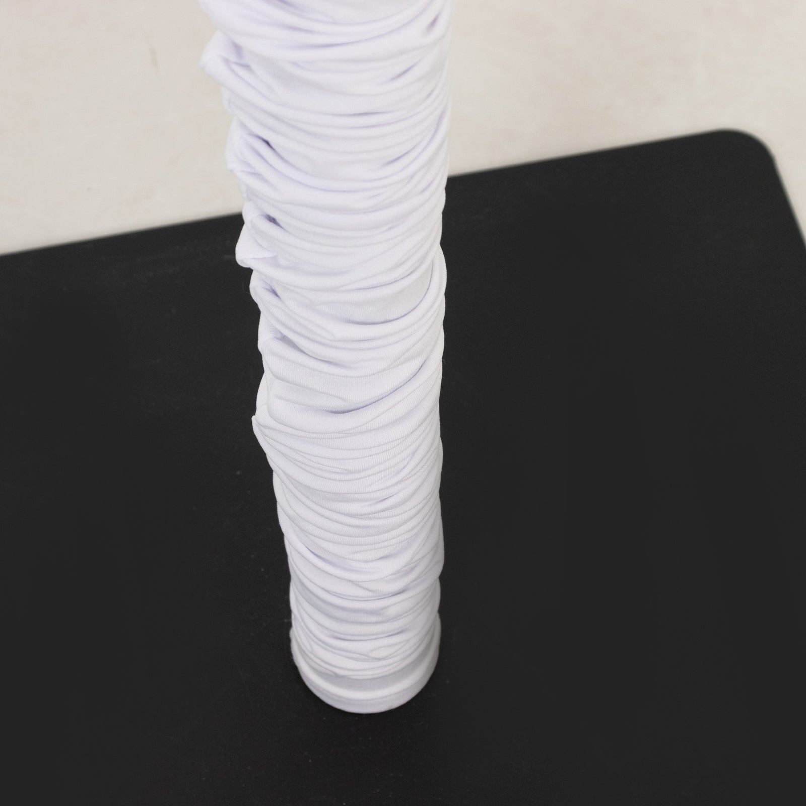 White spandex pole cover for event setup and lighting use.