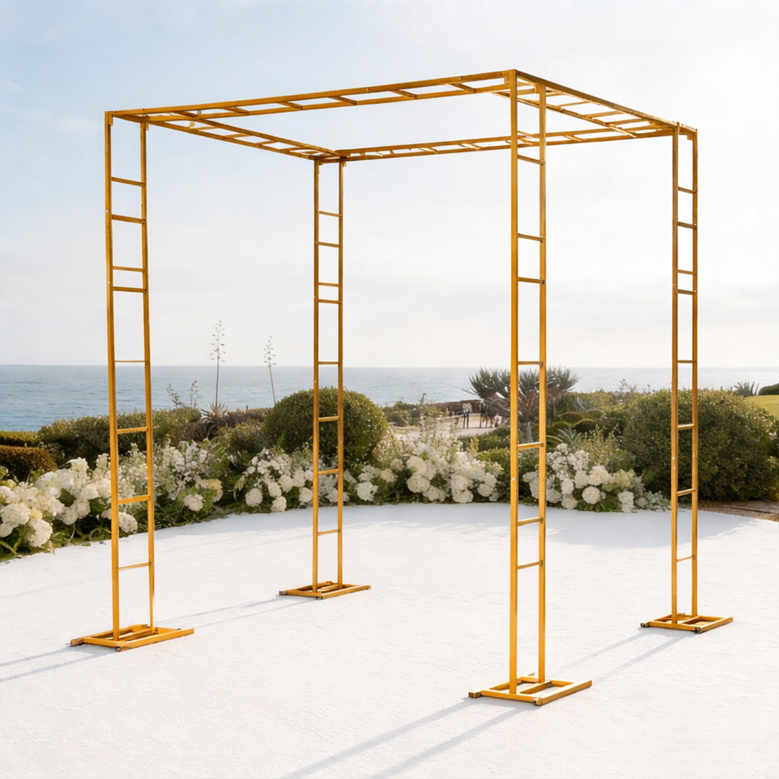 Gold metal event arch and canopy frame against a scenic outdoor backdrop.