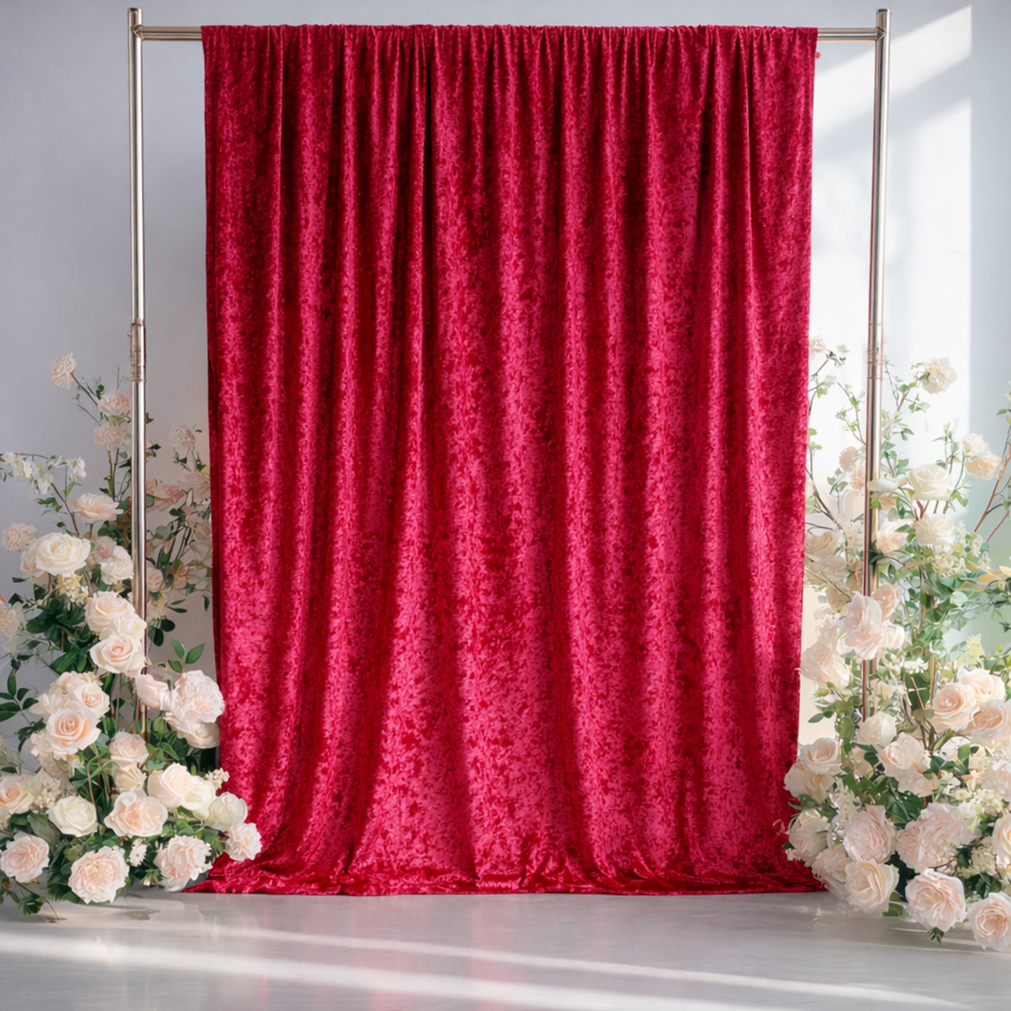 Elegant red velvet backdrop with white roses for events or photography.