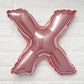 Rose gold matte letter balloon "X" on a white background.