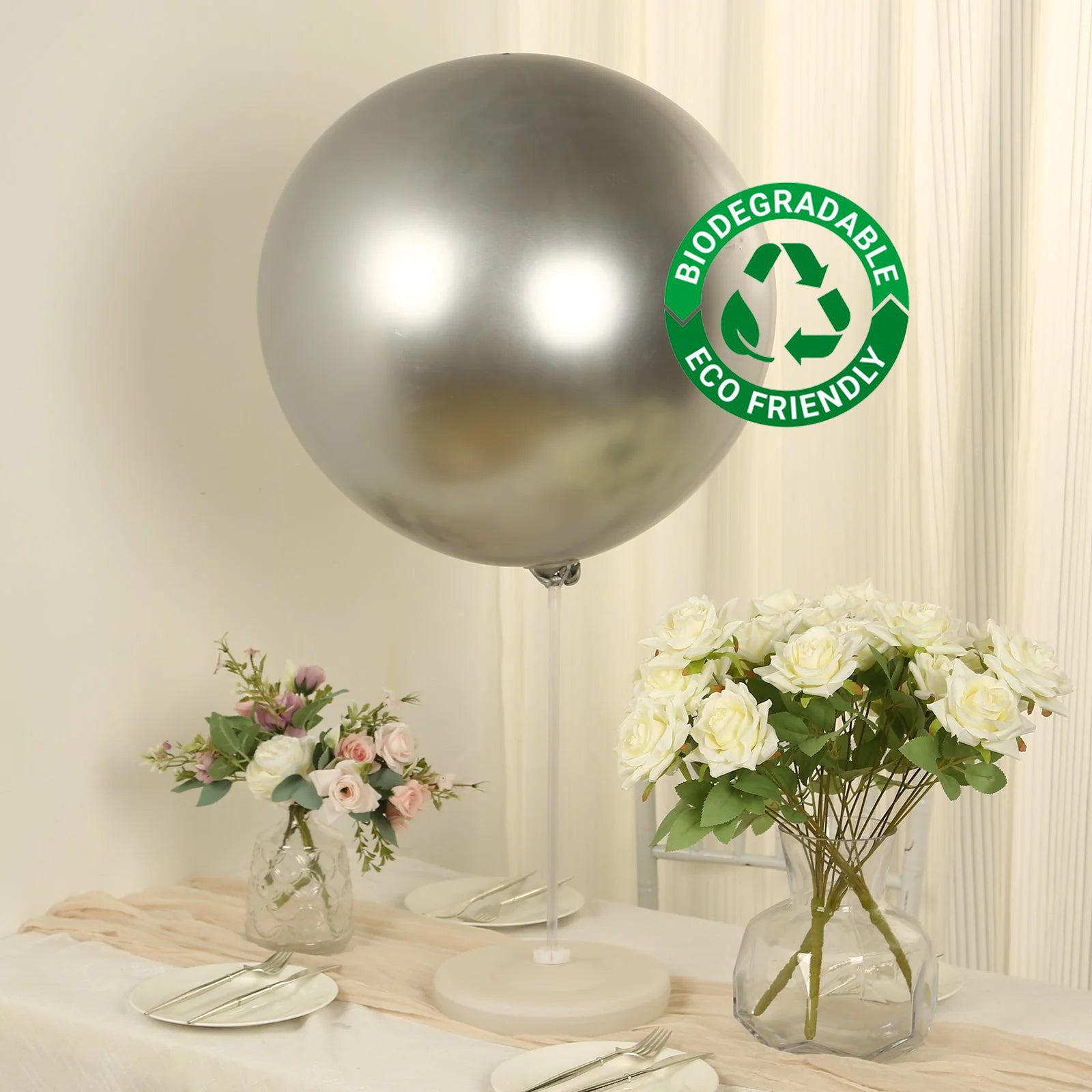 Metallic chrome silver biodegradable balloon on display with flowers.