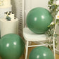 Matte pastel dusty sage green biodegradable balloons on a white chair.