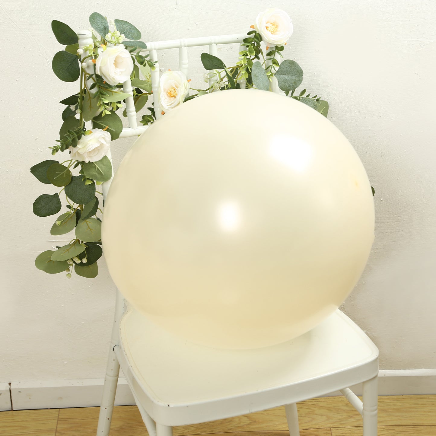 Matte pastel cream biodegradable balloon on a chair with greenery.
