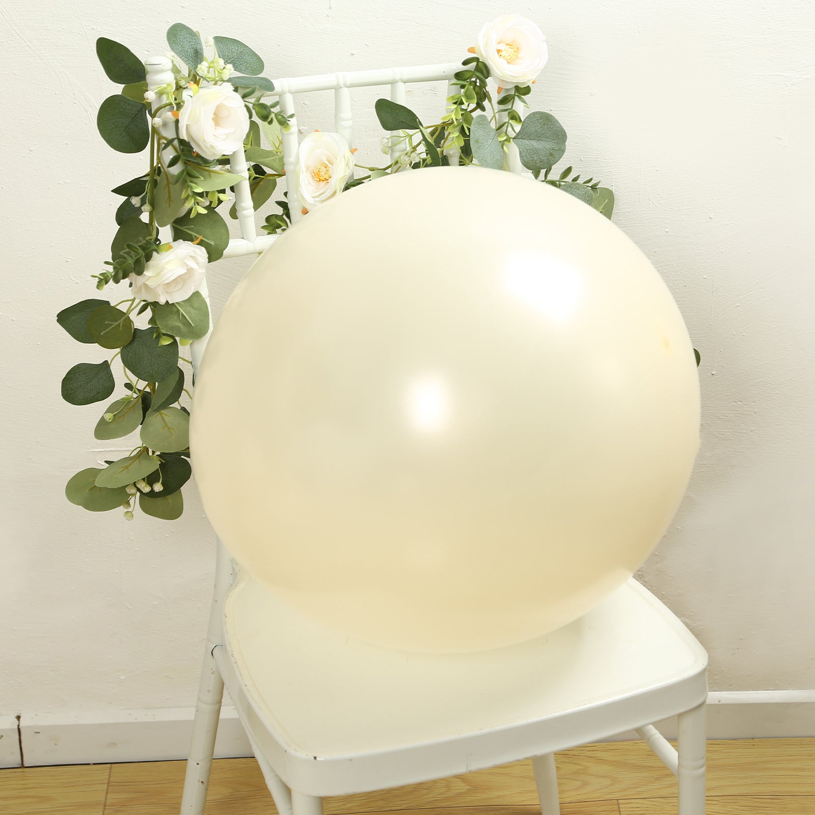 Matte pastel cream biodegradable balloon on a chair with greenery.