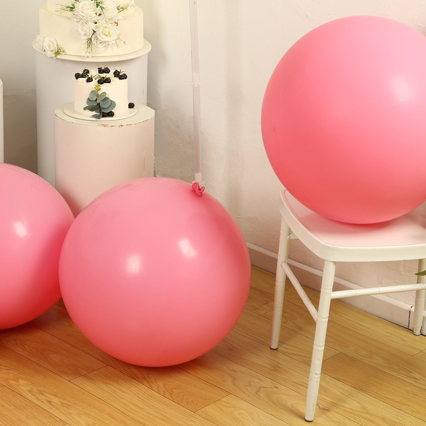 Large matte pastel pink biodegradable balloons in a bright setting.
