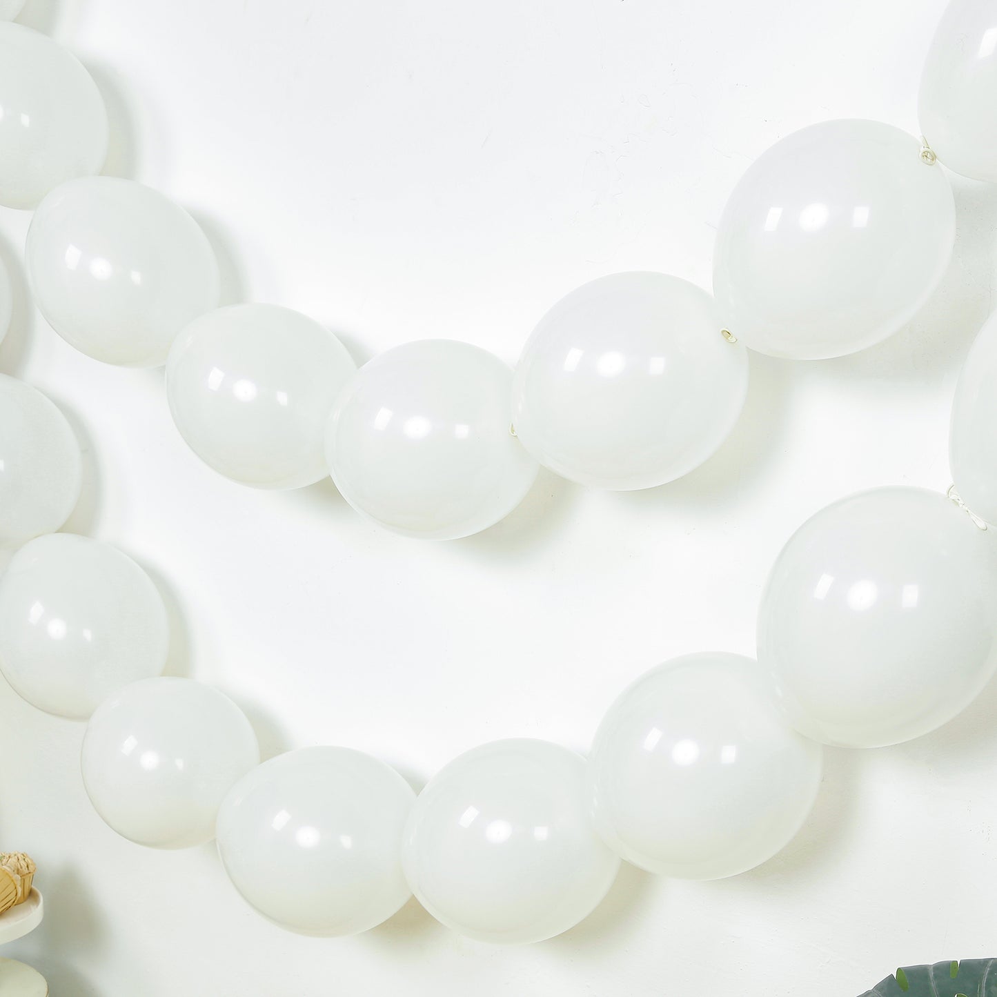 Matte pastel white biodegradable linking balloons in a decorative chain.
